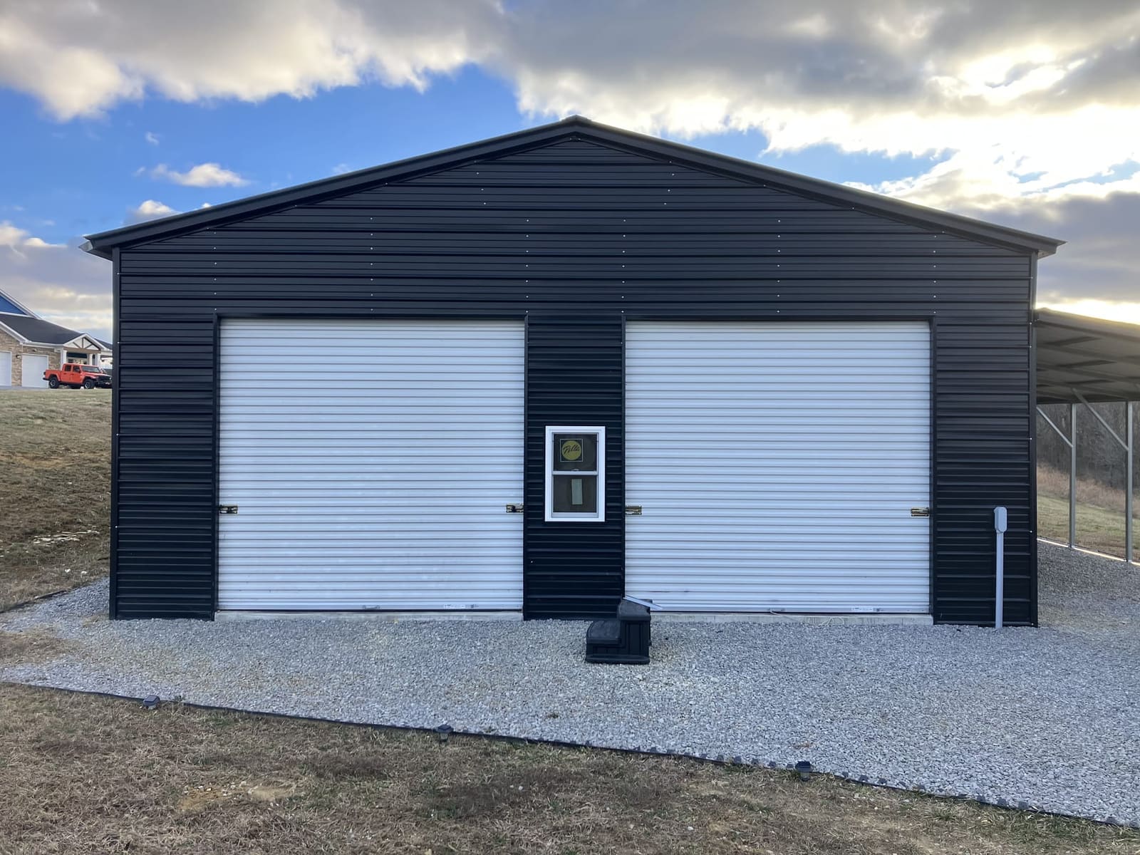 Custom metal garage with white roll-up doors built in Somerset, KY